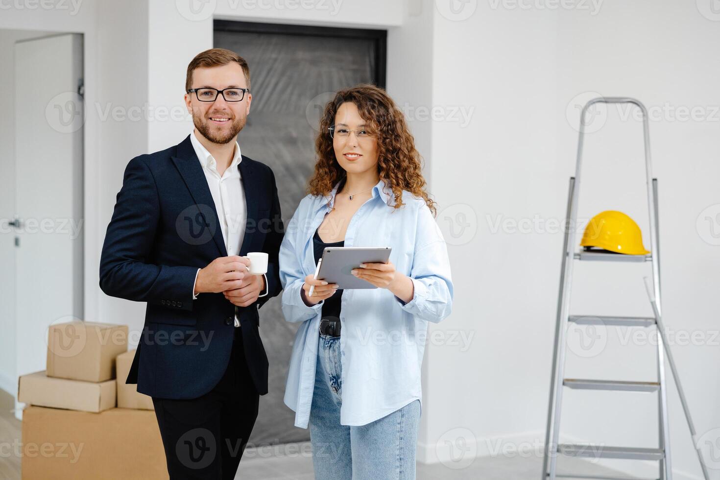 Young designer and customer businessman are designing interior standing with digital tablet in the new living room interior. photo