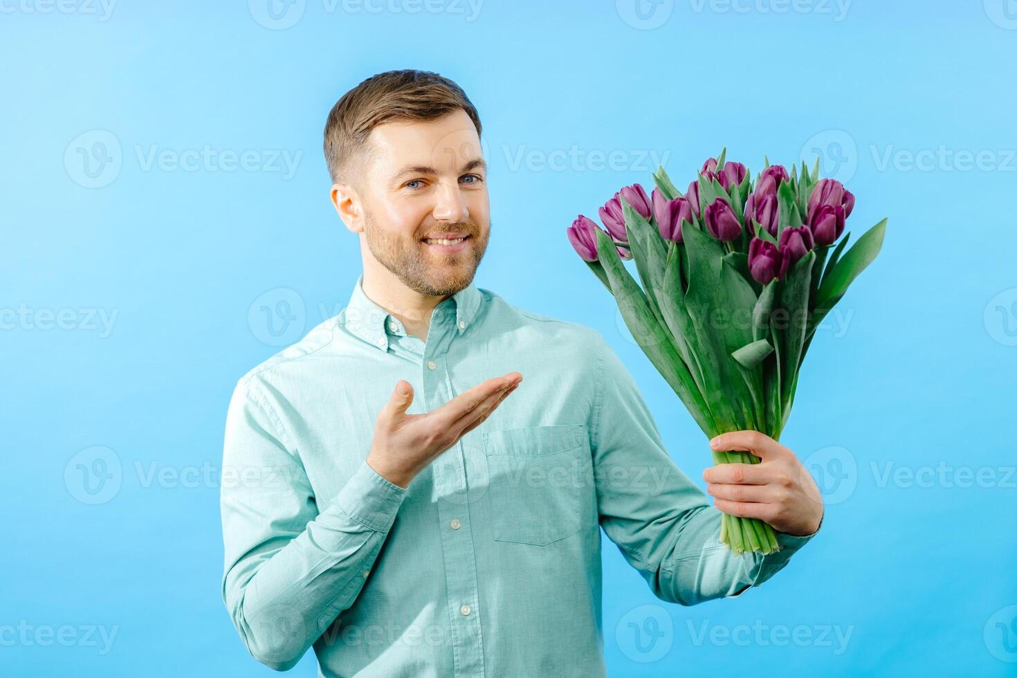 Man's hand hold bouquet of purple tulips on dark background. Spring flowers for Mother's Day, International Women's Day, birthday photo