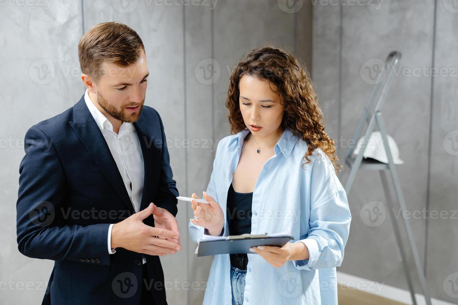 A young designer discusses the plans and design of the room with the customer. The concept of repair on modern design photo