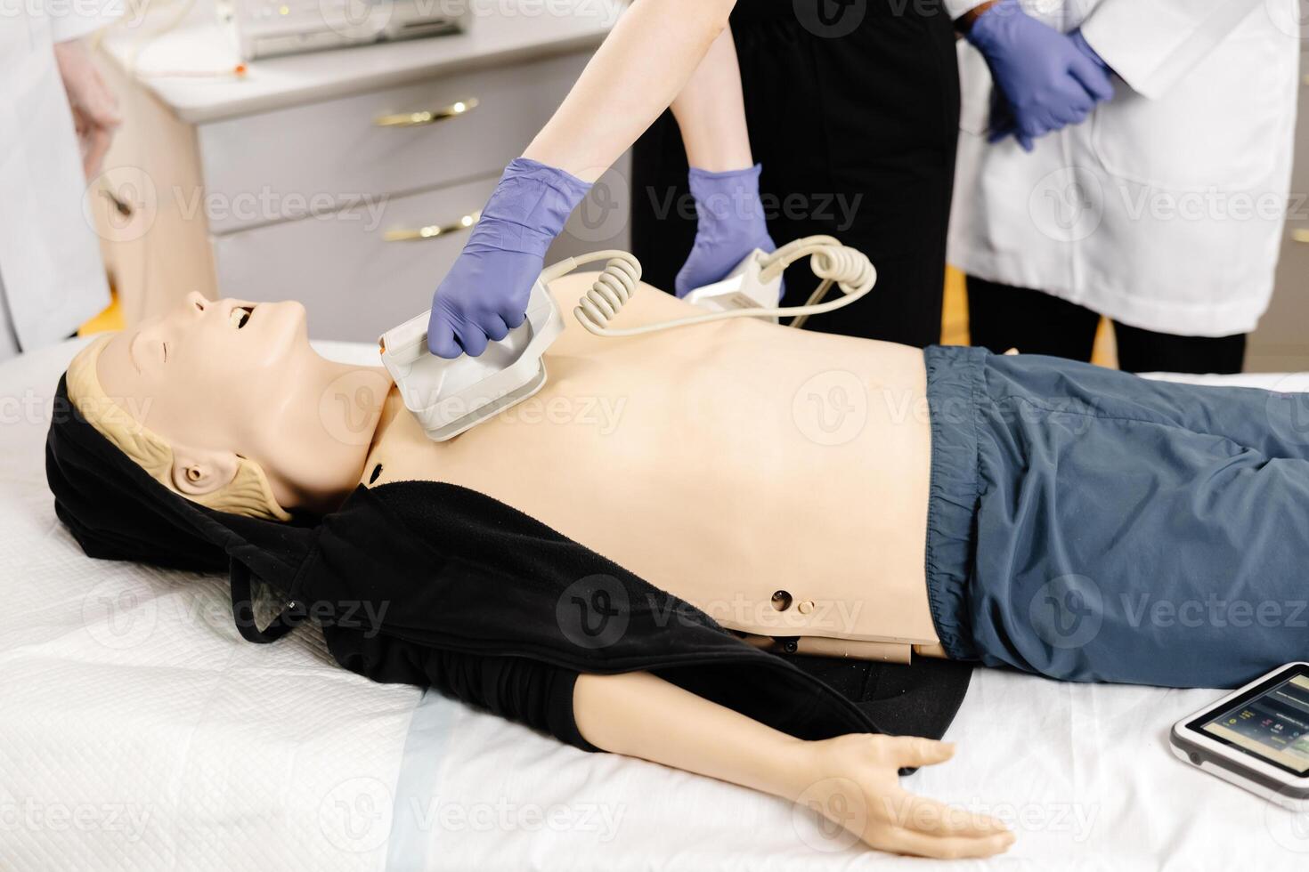 Paramedics practicing defibrillation on a medical manikin during first aid training photo