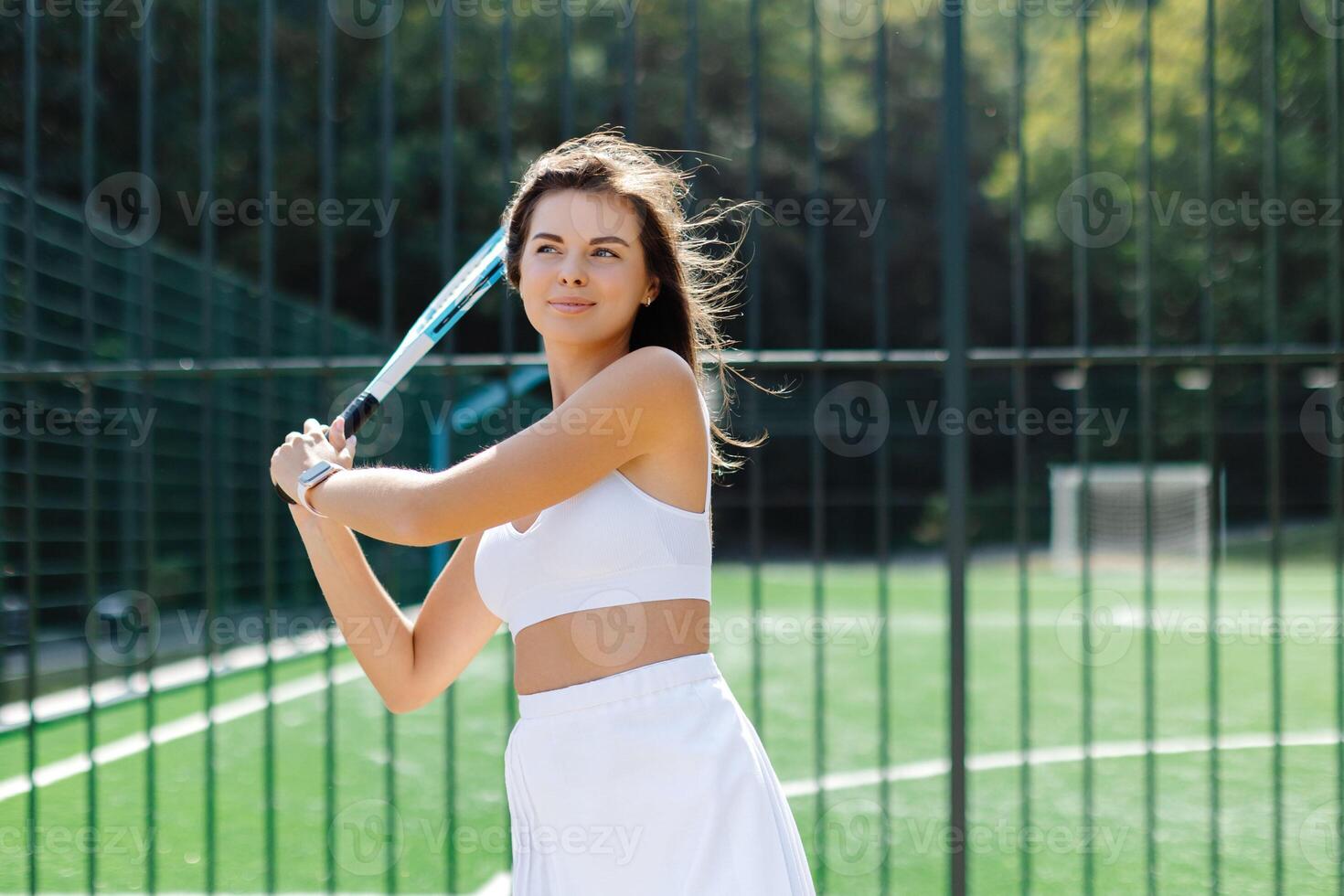 Young fFYoung female tennis player holding racket posing on court photo