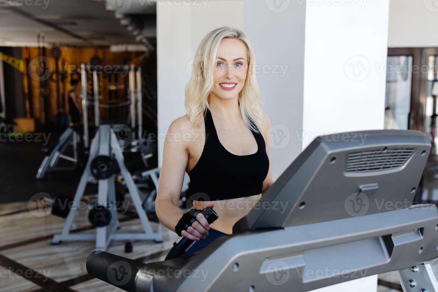 Determined sportswoman running on treadmill in modern gym photo