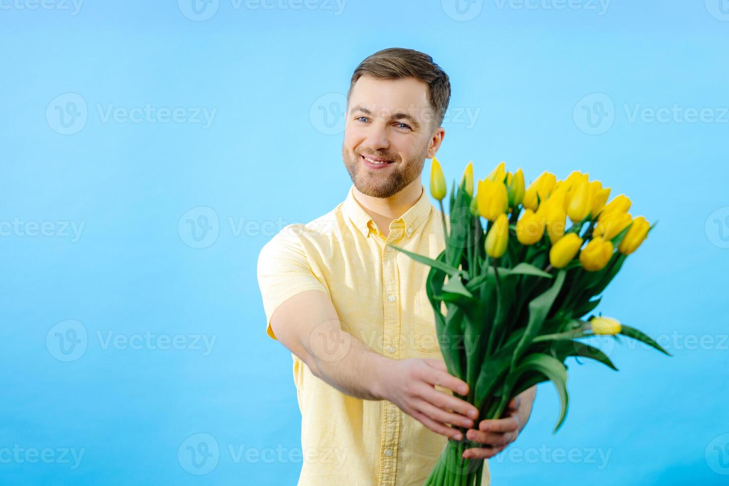 Man holding bouquet of flowers in front of face. photo