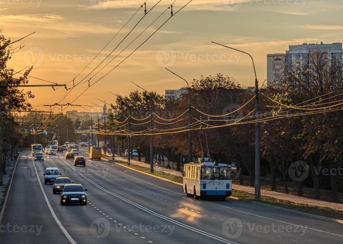 city street in evening light with traffic moving along it photo