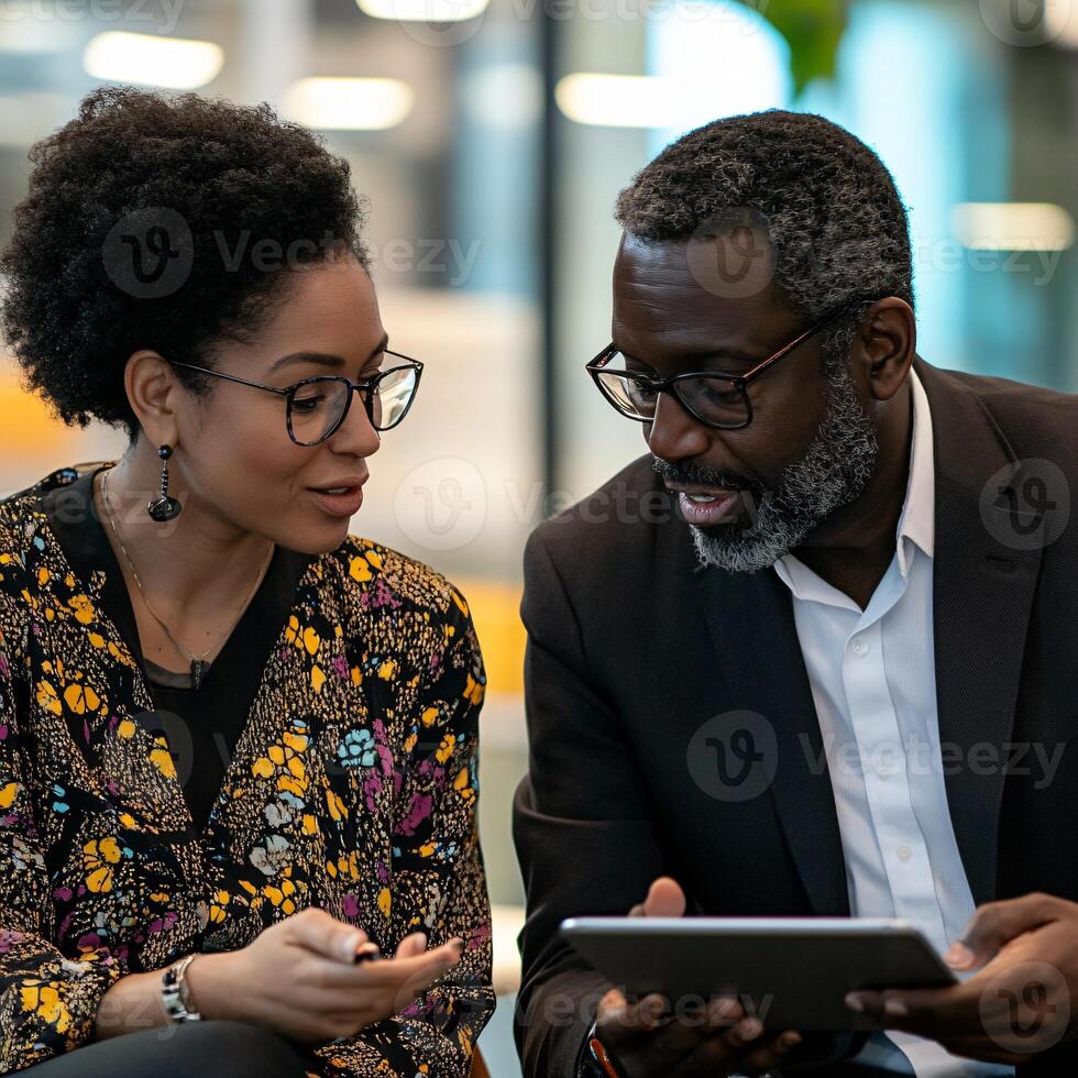 Two business colleagues are engaged in focused conversation together photo