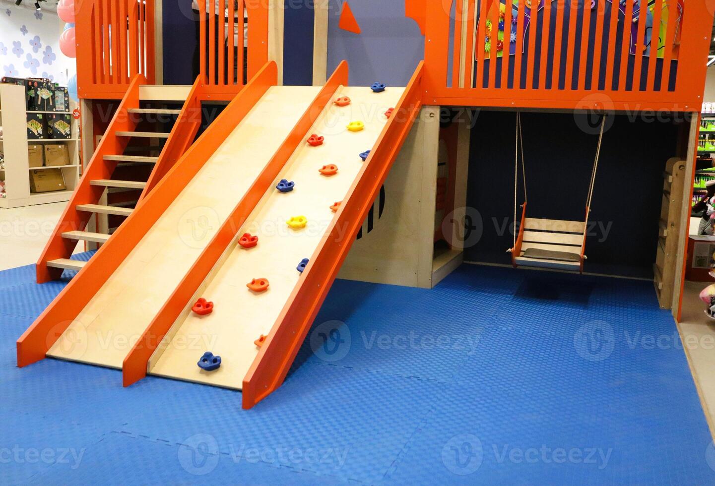 Bright, fun playground equipment with an exciting slide and a challenging climbing wall photo