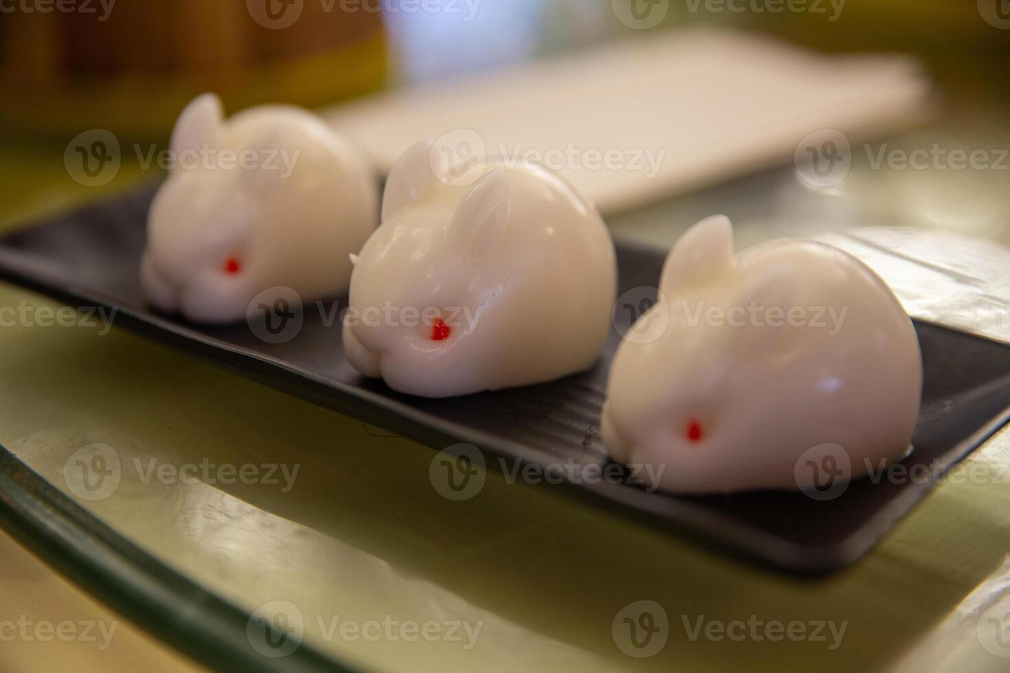 A black tray with three white rabbits on it photo