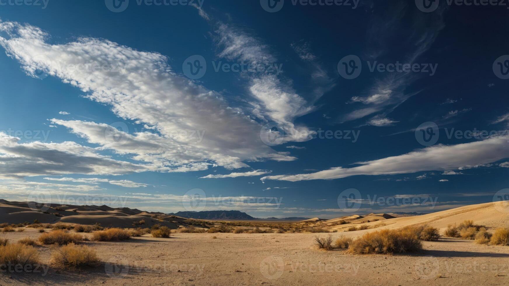 A panoramic view of a desert landscape with clouds and distant hills under a blue sky. photo