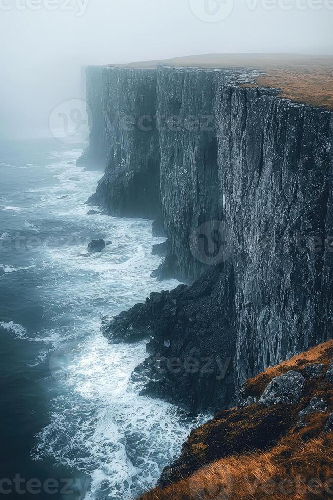 Dramatic Coastal Cliffs and Ocean Waves in Misty Weather photo