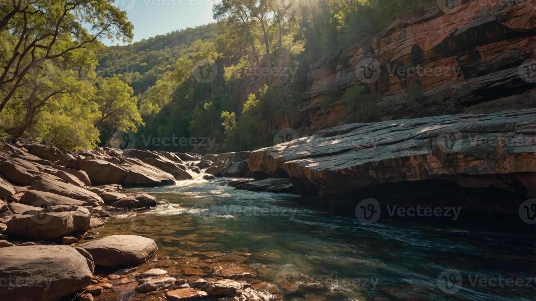 A serene river flows through rocky terrain, surrounded by lush greenery and sunlight. photo