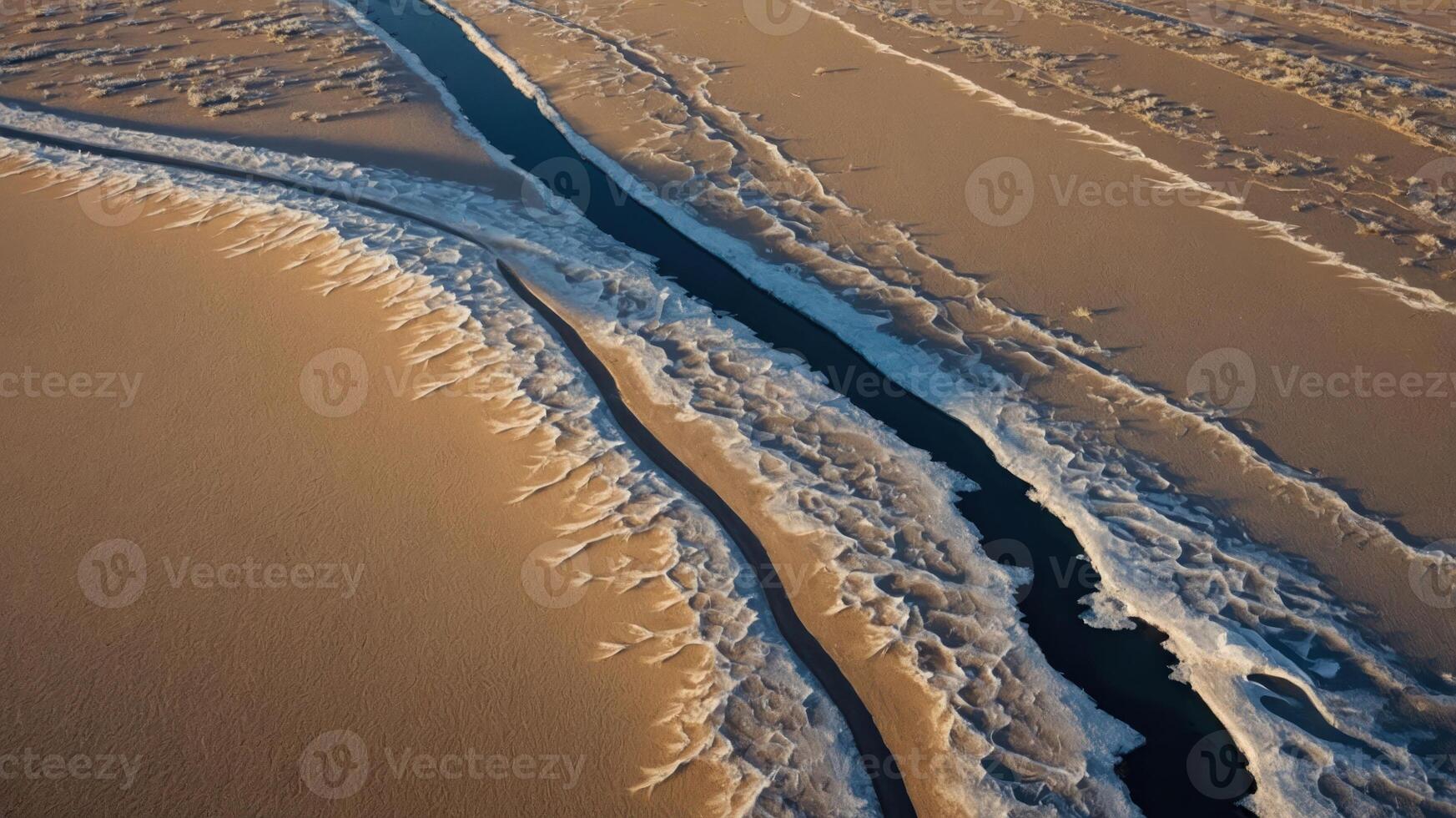 Aerial view of a winding river through sandy terrain, showcasing natural patterns and textures. photo