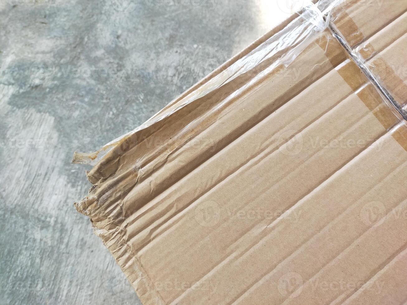 cardboard partially visible against a cement textured background photo