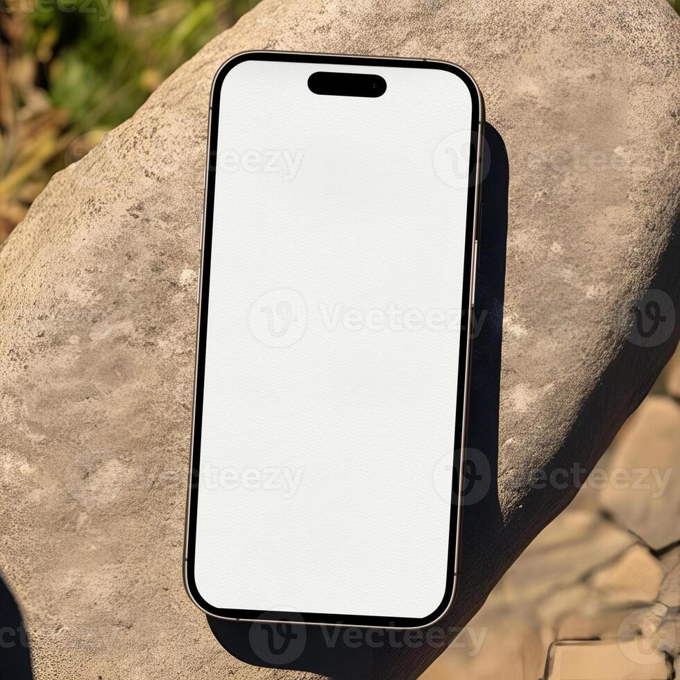 Modern Smartphone with Blank Screen Placed on a Textured Rock Surface in Natural Sunlight photo