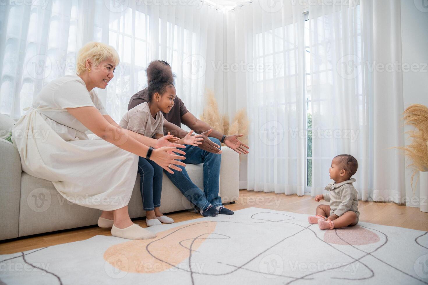 Family enjoys playtime with baby in bright, modern living room filled with natural light photo