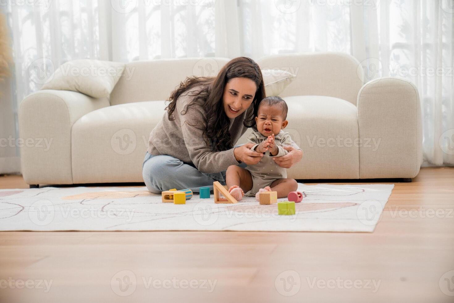 Playing with blocks, a mother engages her baby in creative learning at home during the afternoon photo