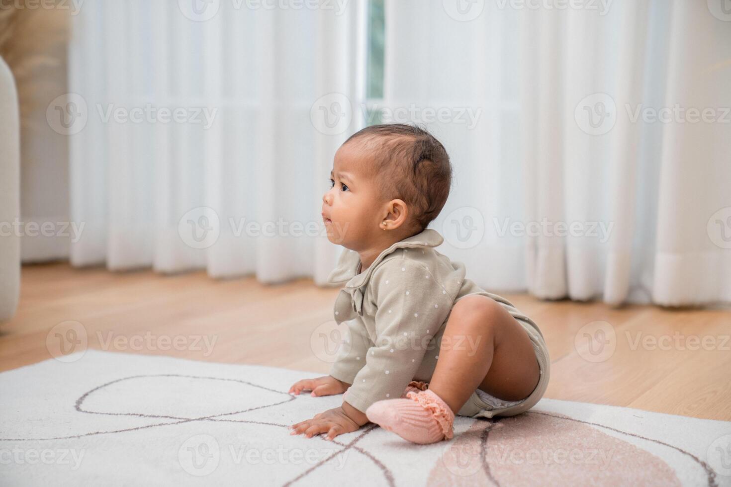 Baby exploring a cozy living room while sitting on a soft rug during afternoon playtime photo
