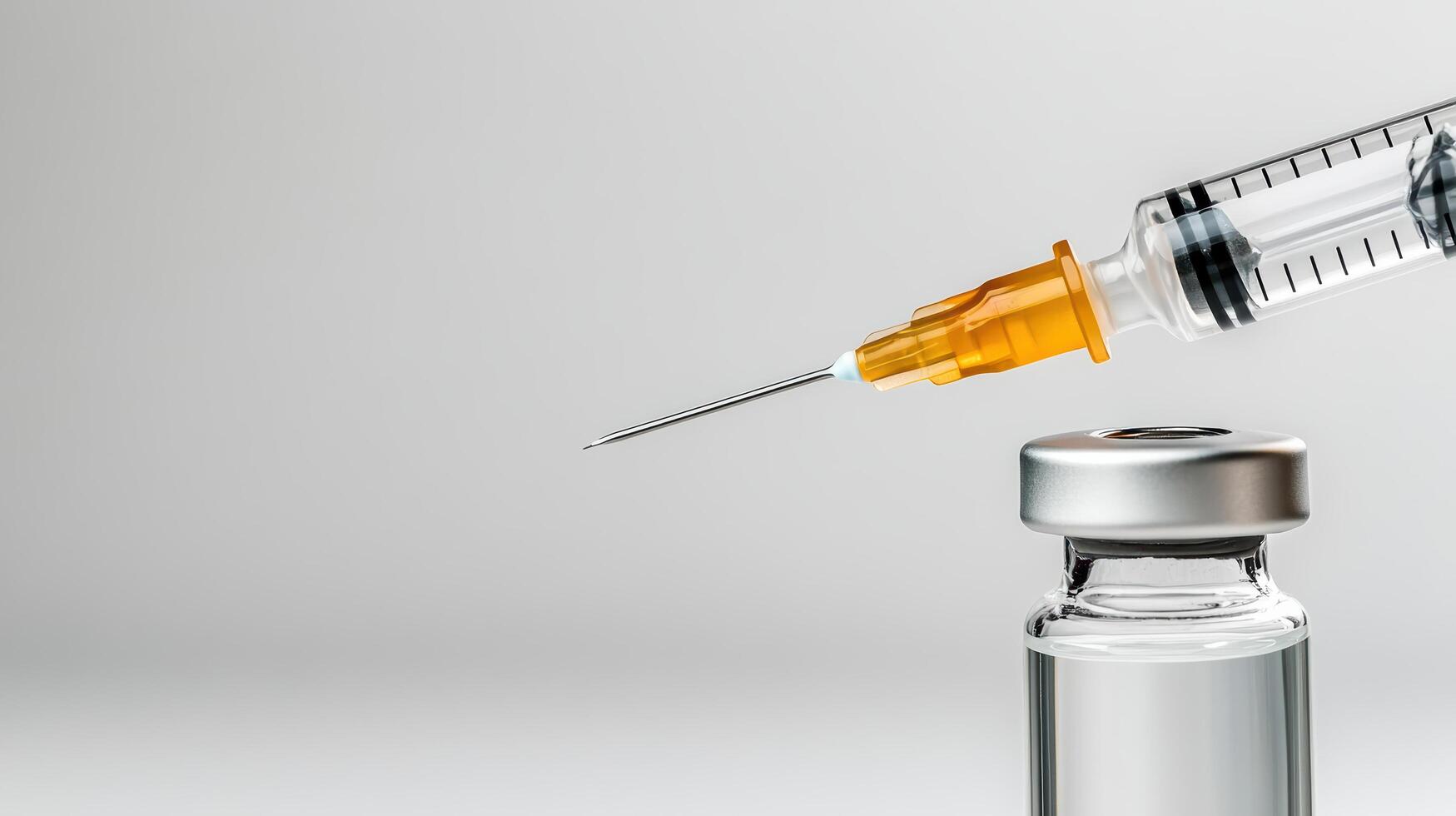 An injection is being placed into a glass vial photo