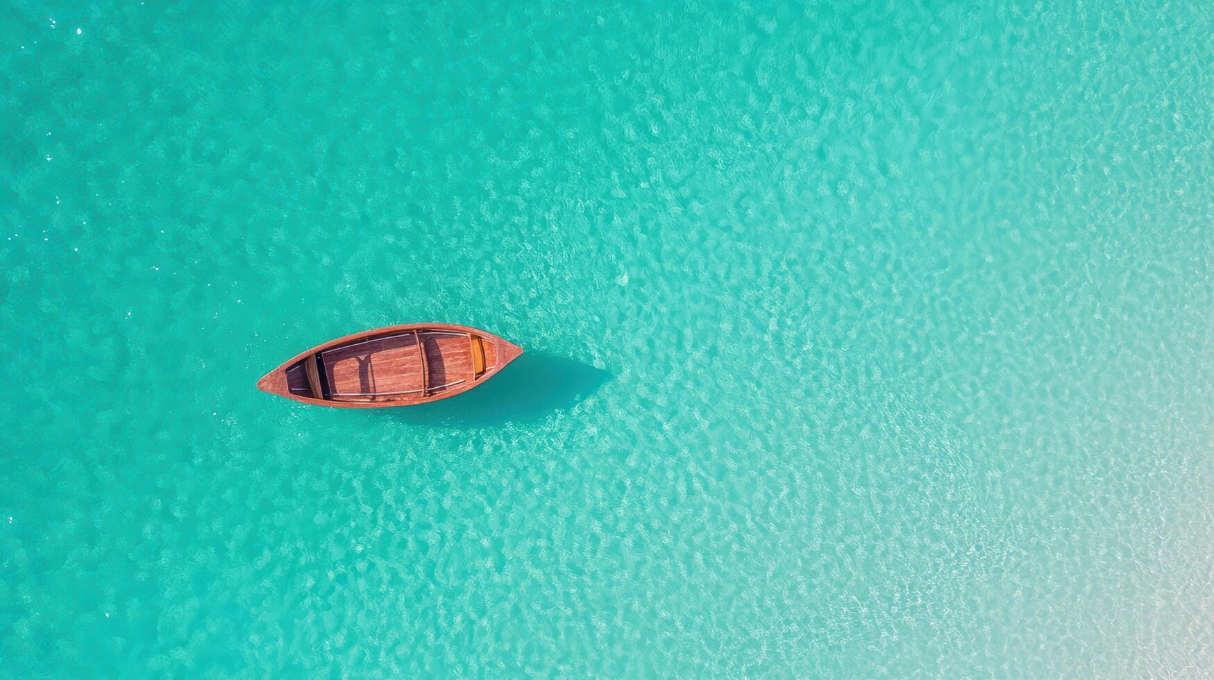 serene boat floating on clear turquoise water creates peaceful scene photo