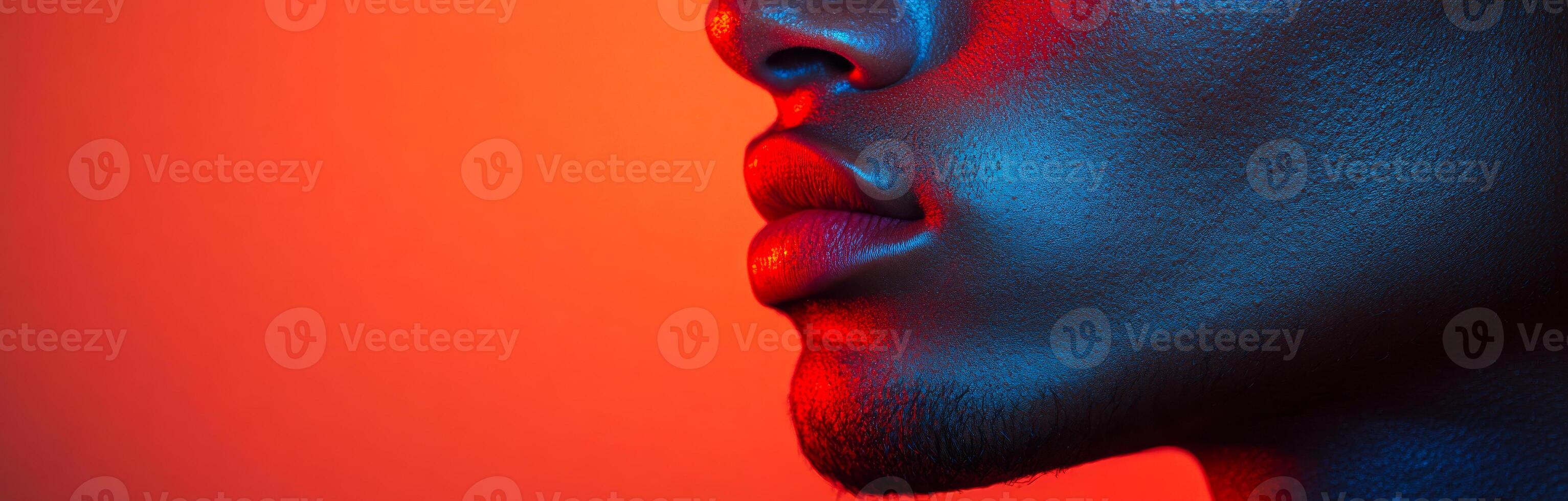 Vibrant portrait of a person. Close-up view of a person's face illuminated with bold red and blue lighting, creating an artistic effect. photo