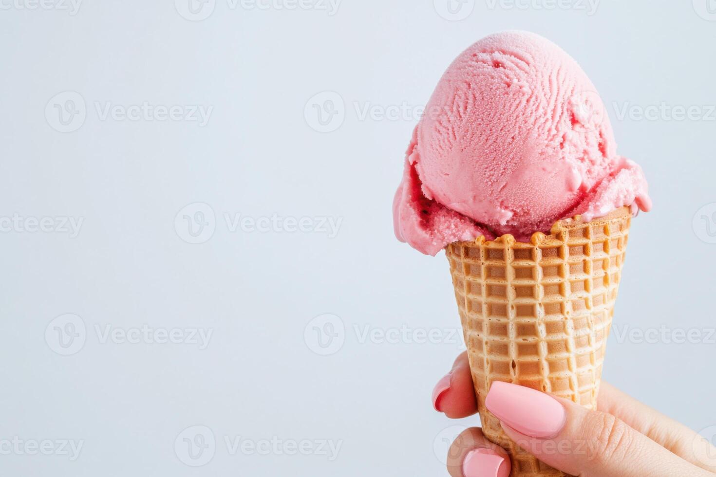 Bright summer afternoon enjoying a red ice cream scoop in a waffle cone with playful hand nails in a warm and cheerful atmosphere photo