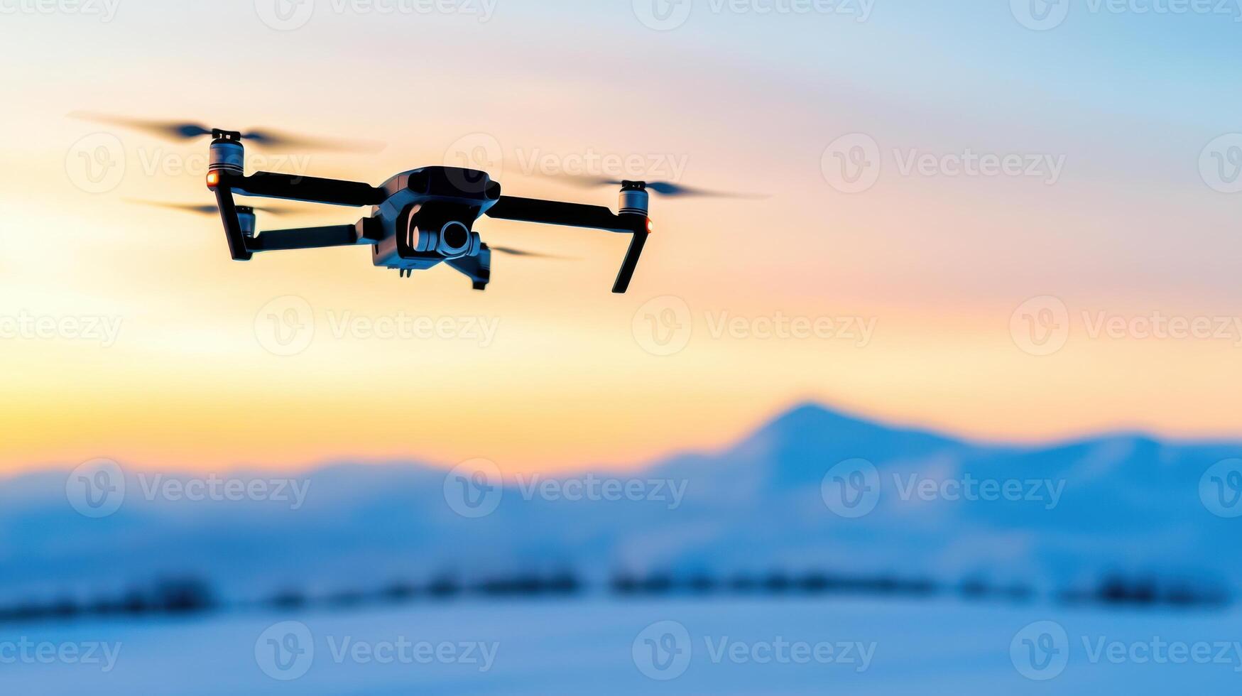 Drone soars above snowy mountains during twilight, capturing tranquil landscapes under a stunning blue hour sky filled with icy hues photo