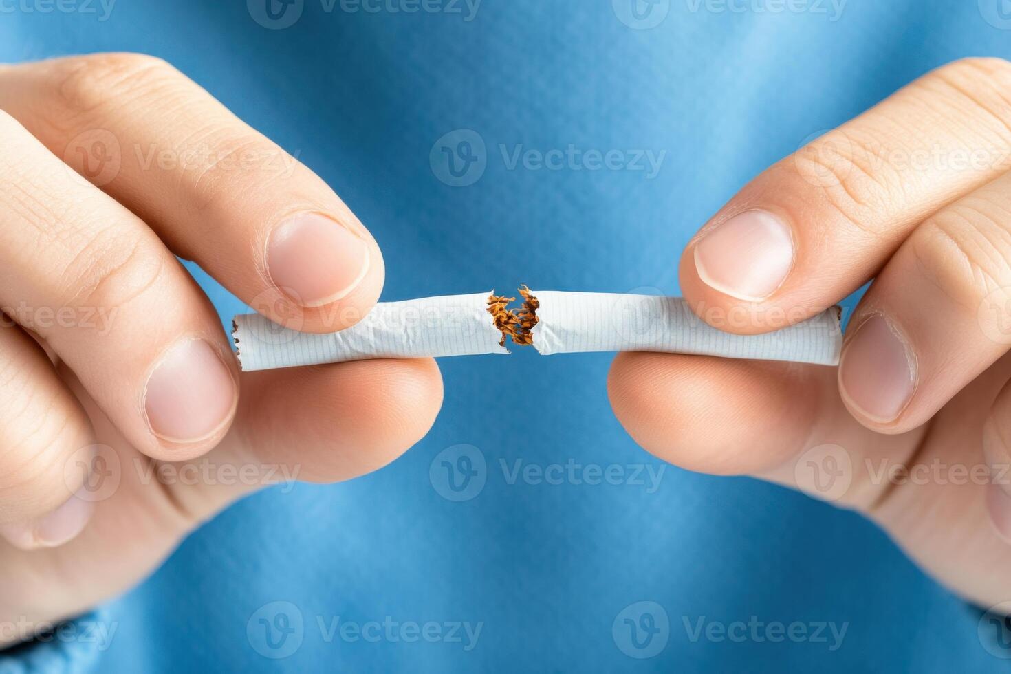 Determined individual breaking a cigarette in half as a symbol of commitment to quitting smoking and choosing a healthier lifestyle photo
