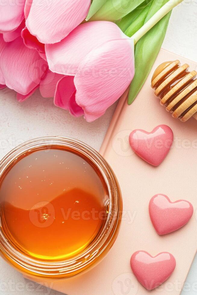 Sweet and romantic flatlay featuring a honey jar, heart candy, and a blush notebook on a peach-toned background photo