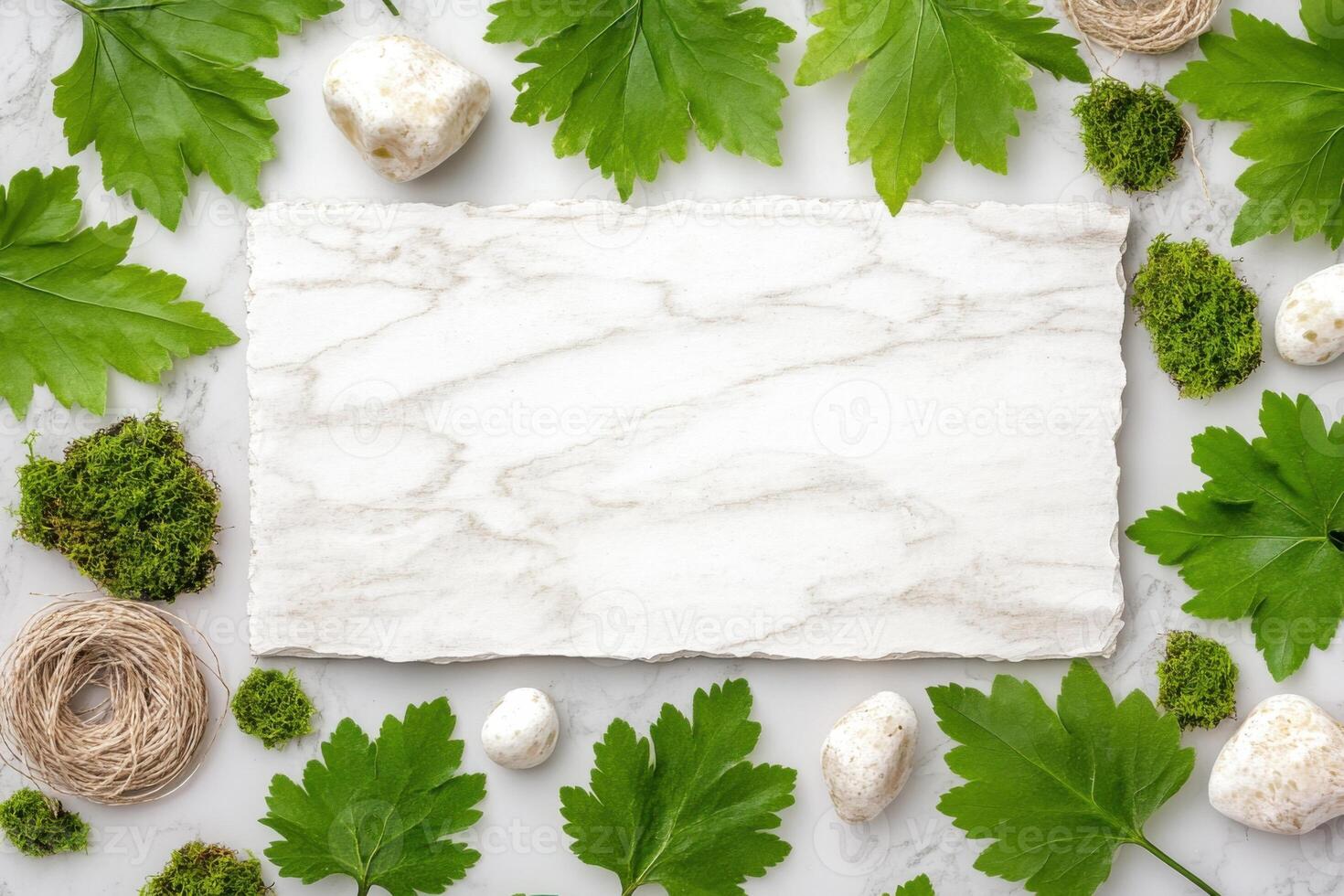Natural elements arranged on a calm, neutral background featuring green leaves, moss, textured paper, twine, and wooden pieces photo