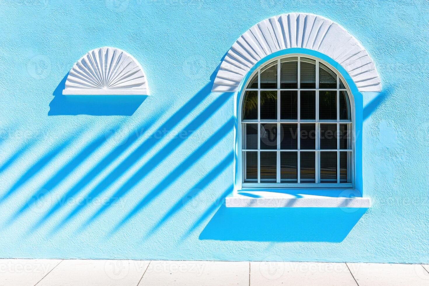 Creative architectural facade featuring baby blue color and geometric patterns casting dynamic shadows on a sunny day photo