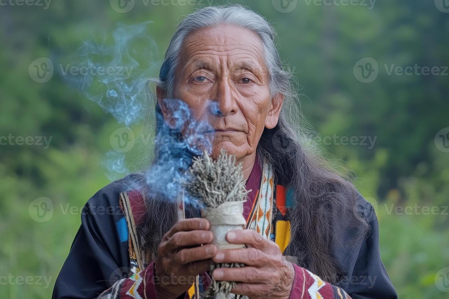 Native American shaman performing a traditional ritual with burning sage photo