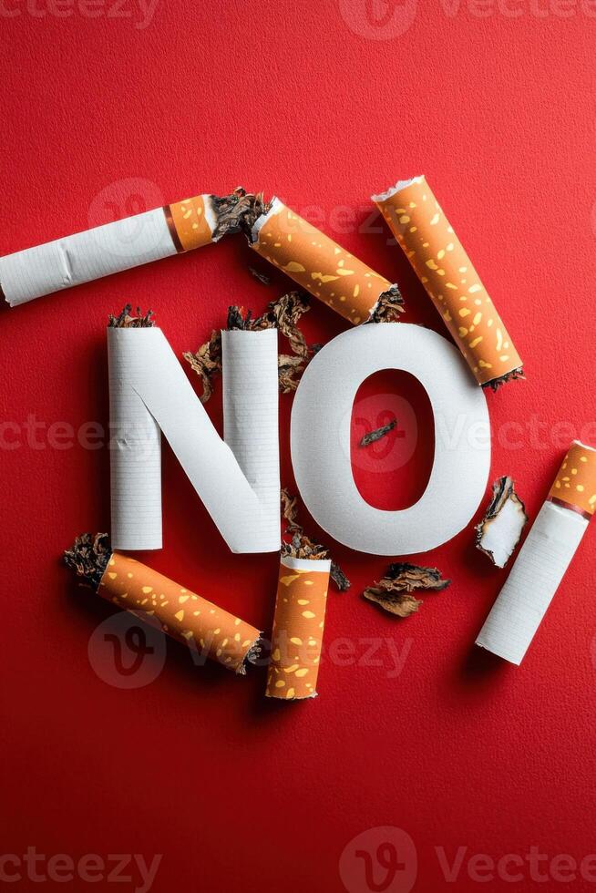 Broken cigarettes forming the word no on red background photo