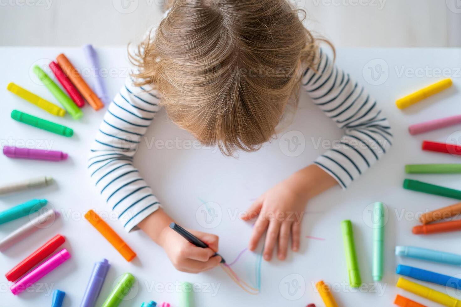 Little girl drawing with colorful markers at white table, top view photo