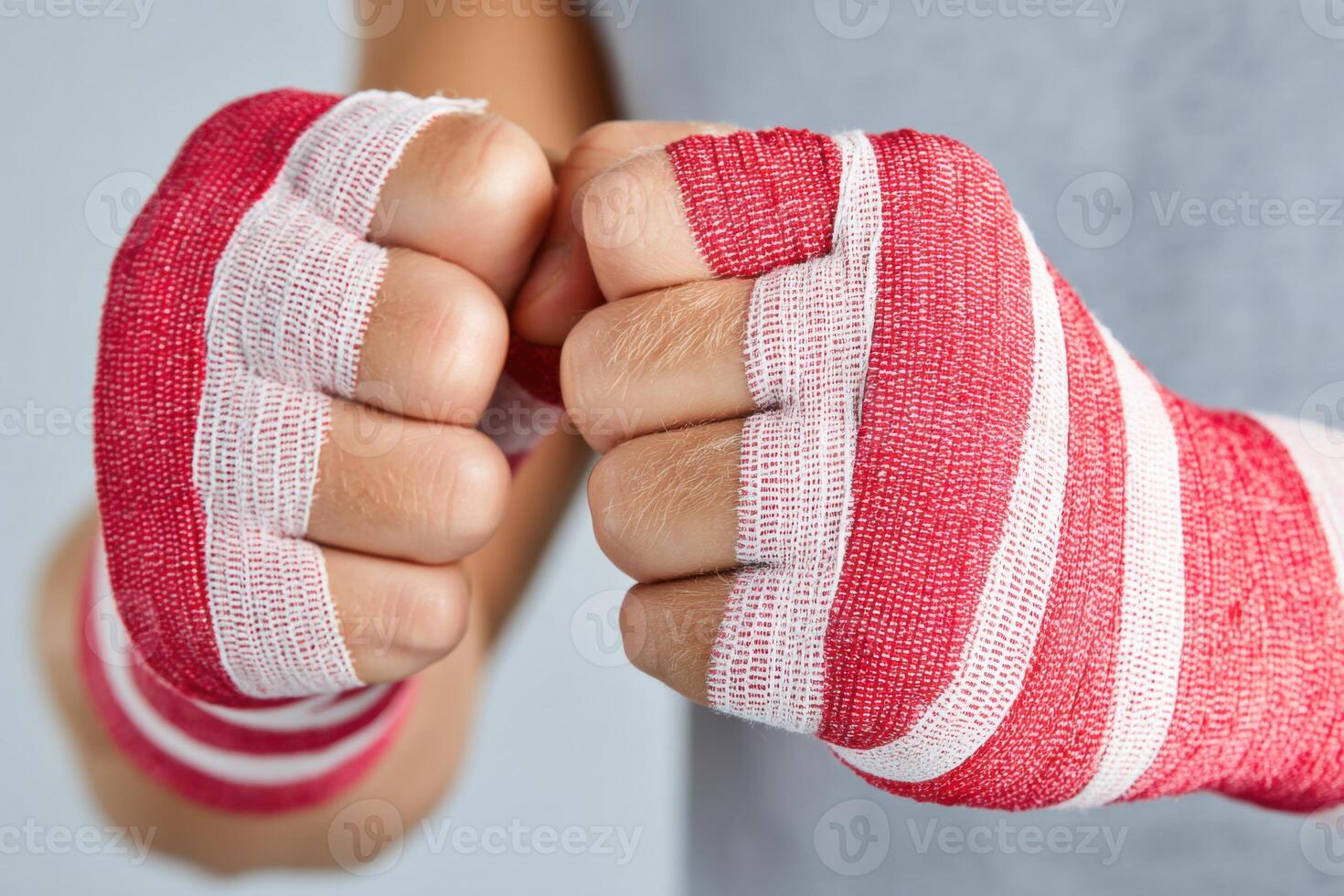 Boxer wrapping hands with red and white boxing bandages photo