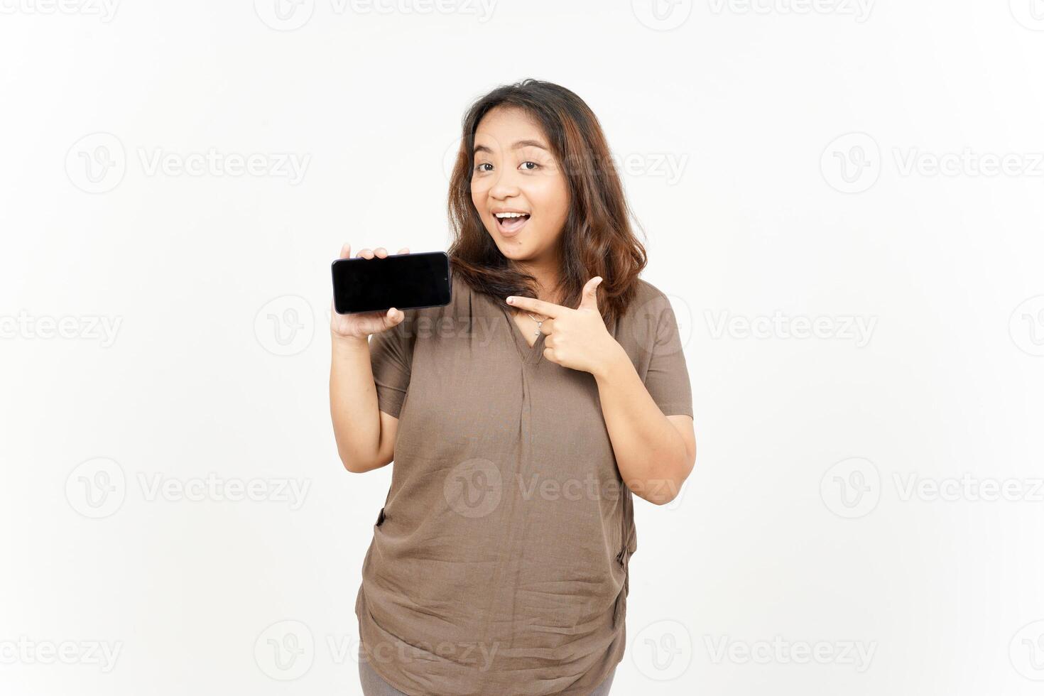A woman holding a cell phone and pointing at it photo