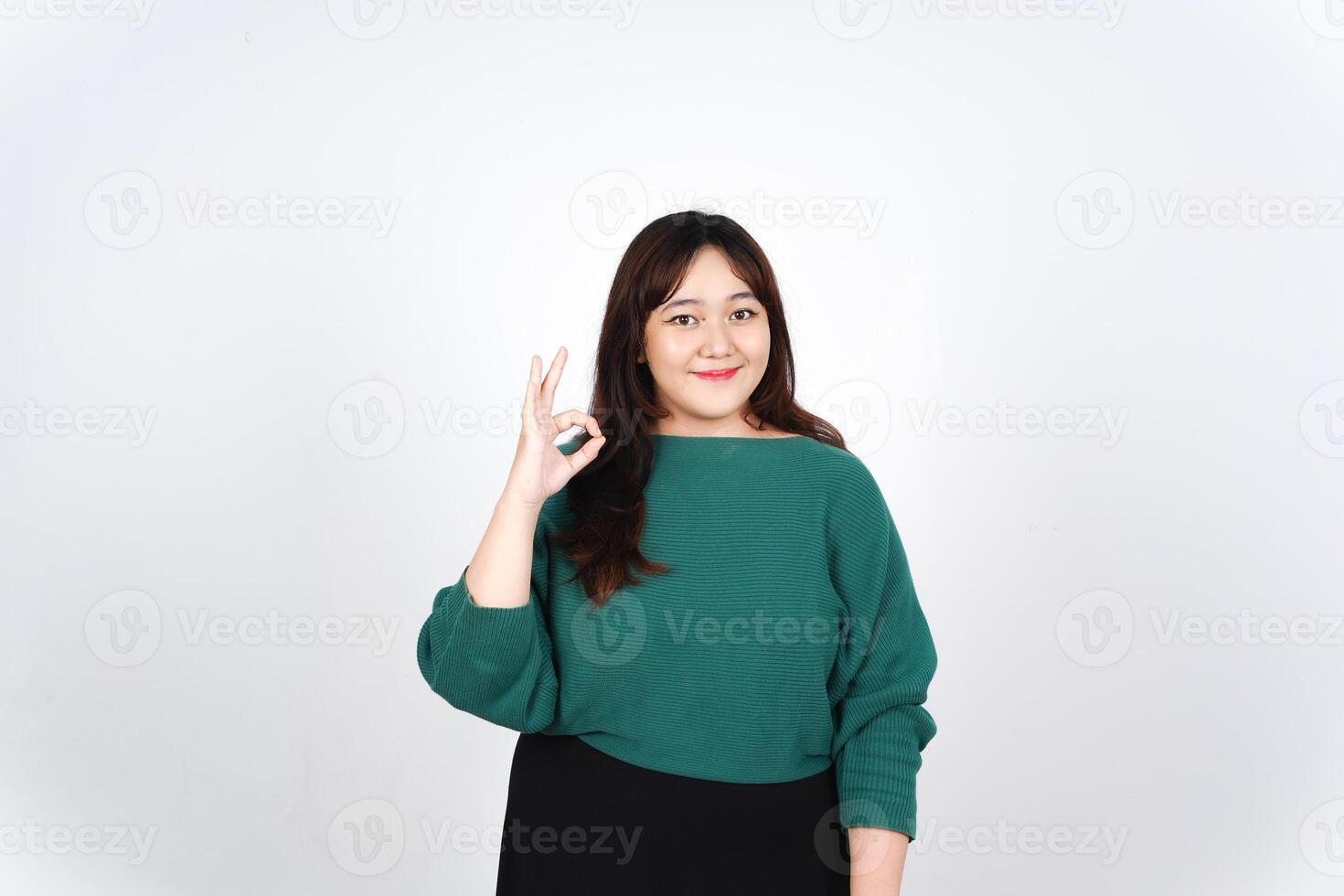 A woman in green shirt and black skirt making the ok sign photo