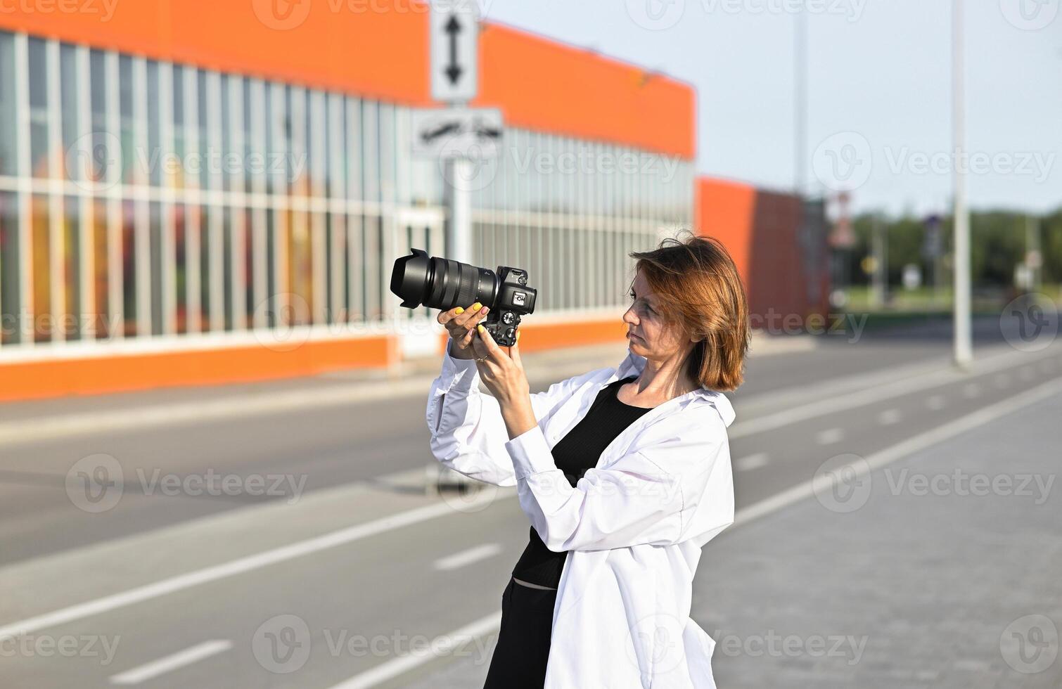 A female photographer is smiling cheerfully while working at her desk. A creative freelance woman is working on a new project. photo