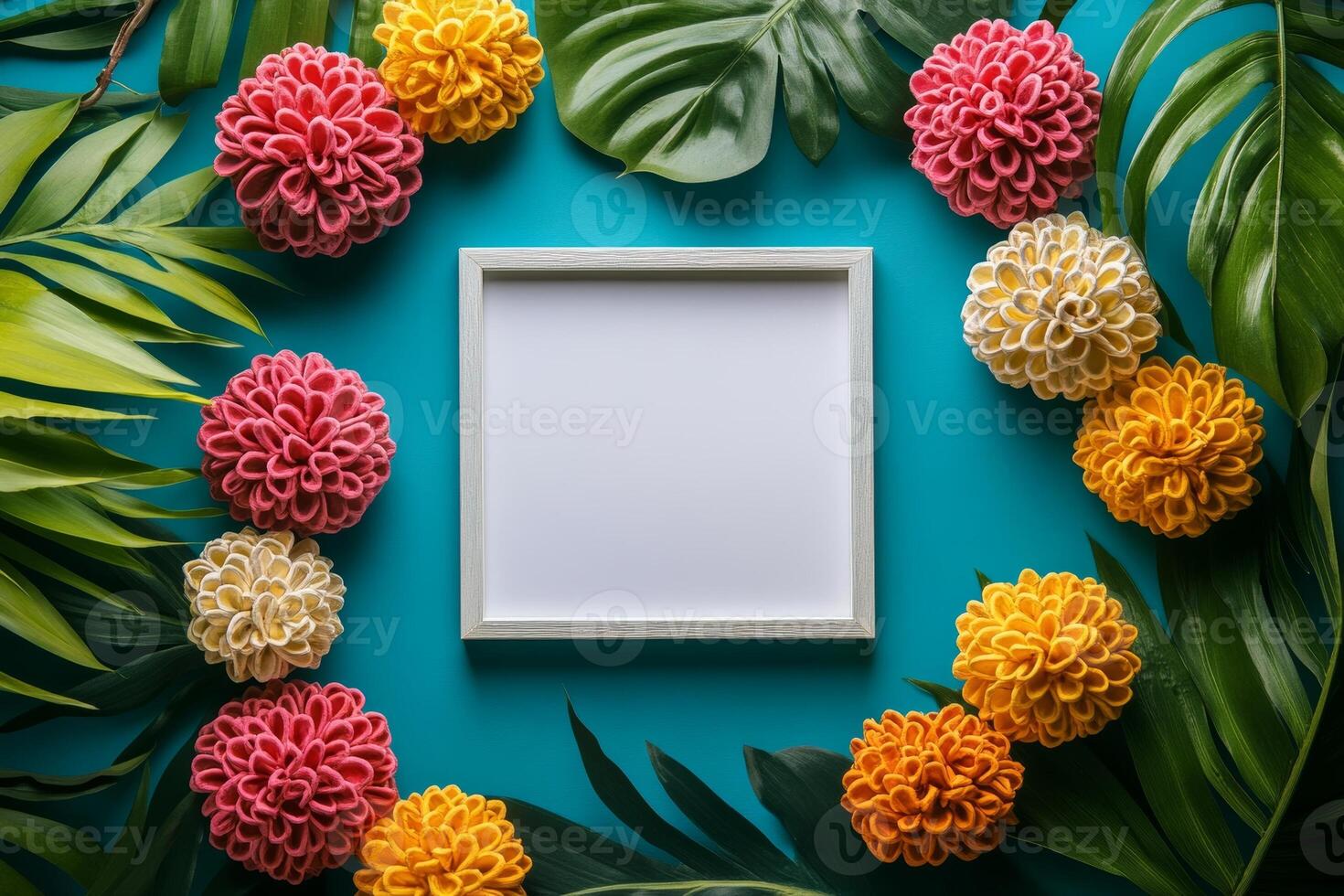 A blank frame surrounded by colorful flowers and leaves on a turquoise background. photo