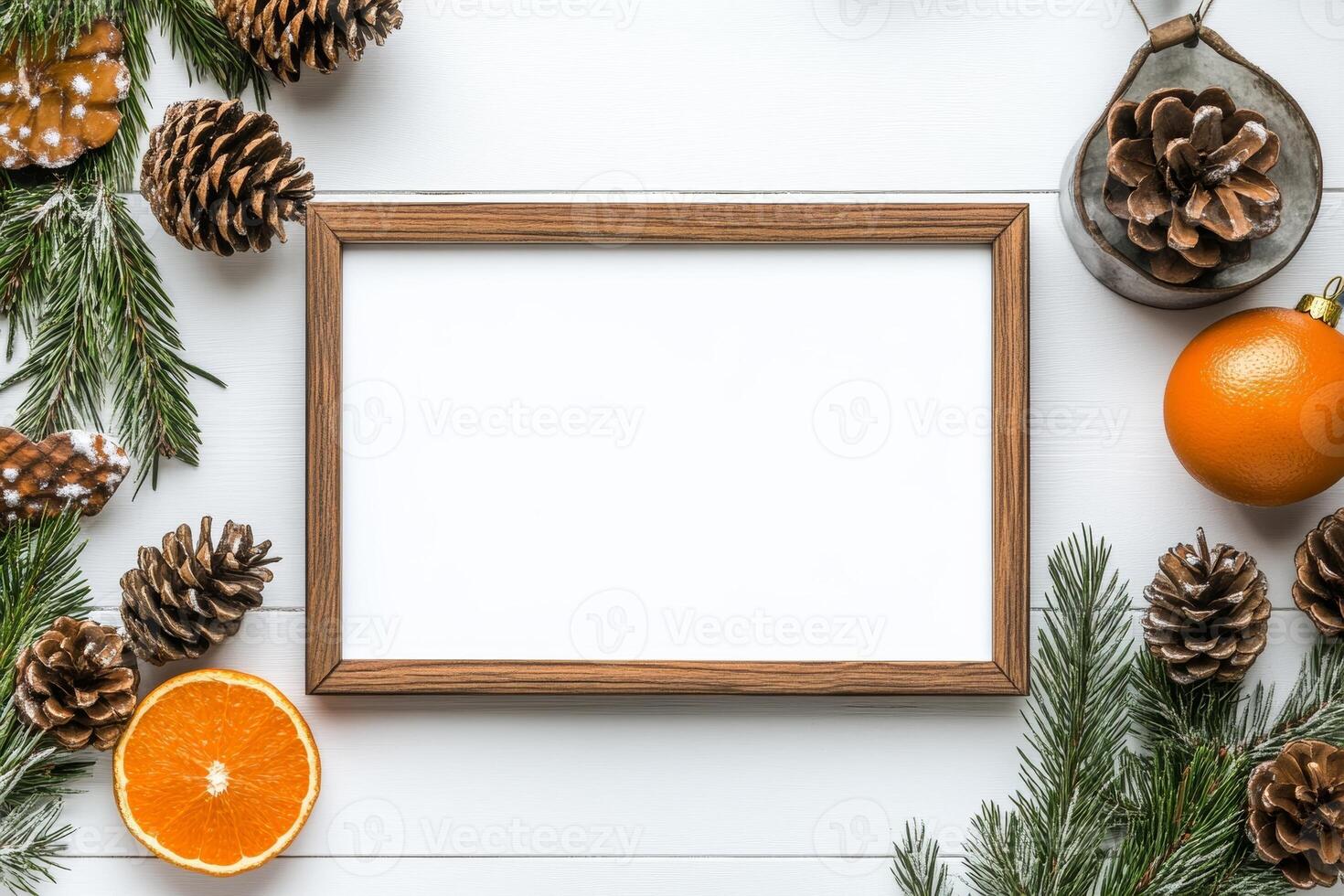 A blank photo frame surrounded by pinecones, orange slices, and greenery for seasonal decoration.