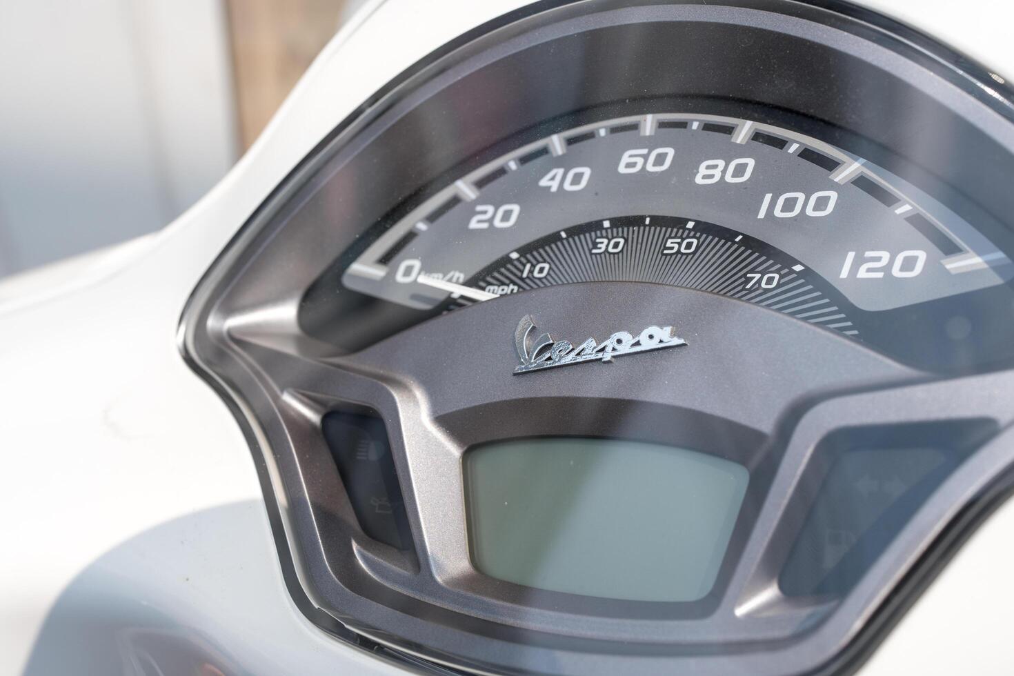 Bangkok, Thailand - March 26, 2025 Dashboard is on a white vespa LX 125 for shows the speed and amount of gasoline in the tank. photo