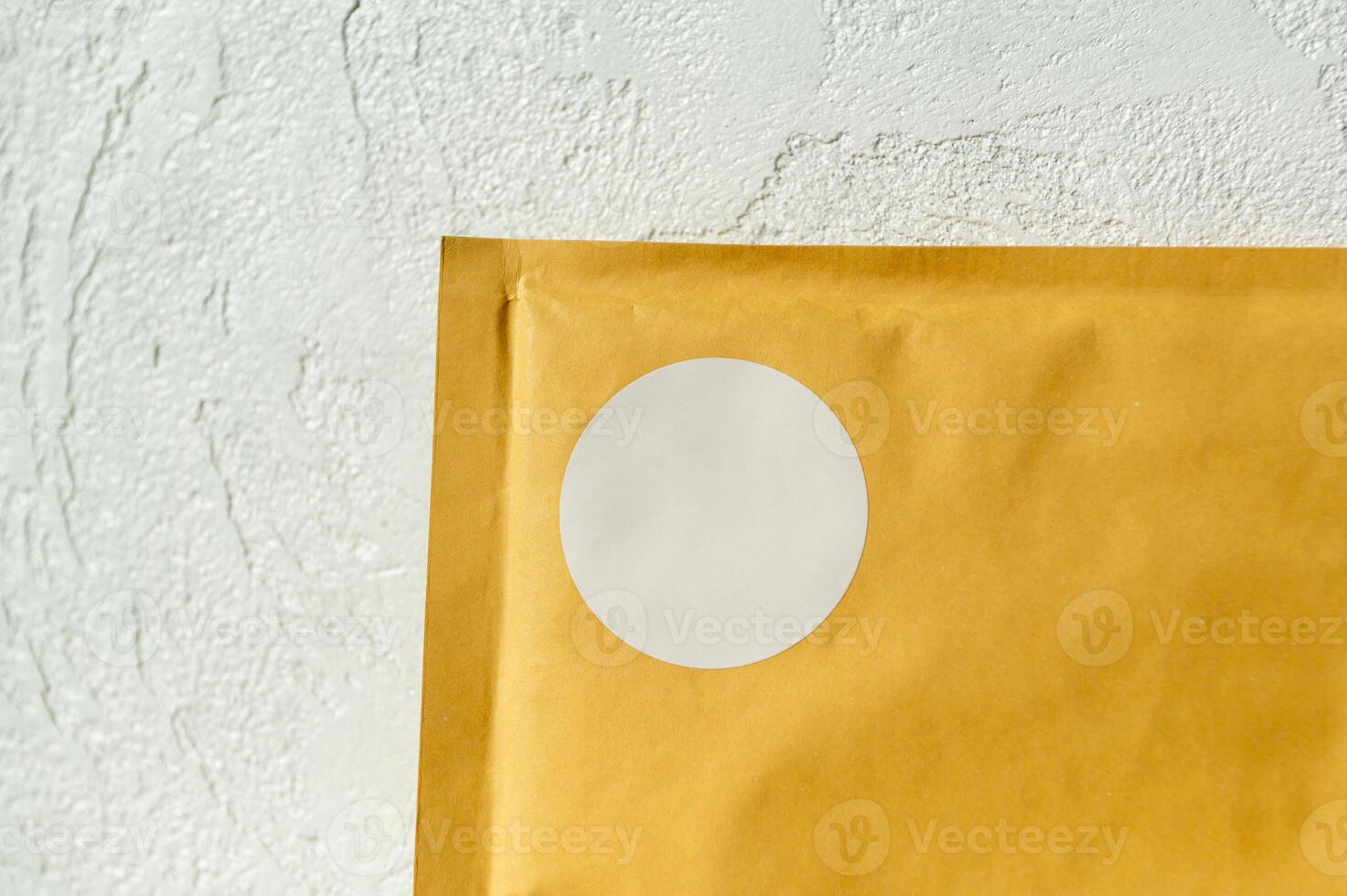 Brown envelope with white seal on textured wall background photo