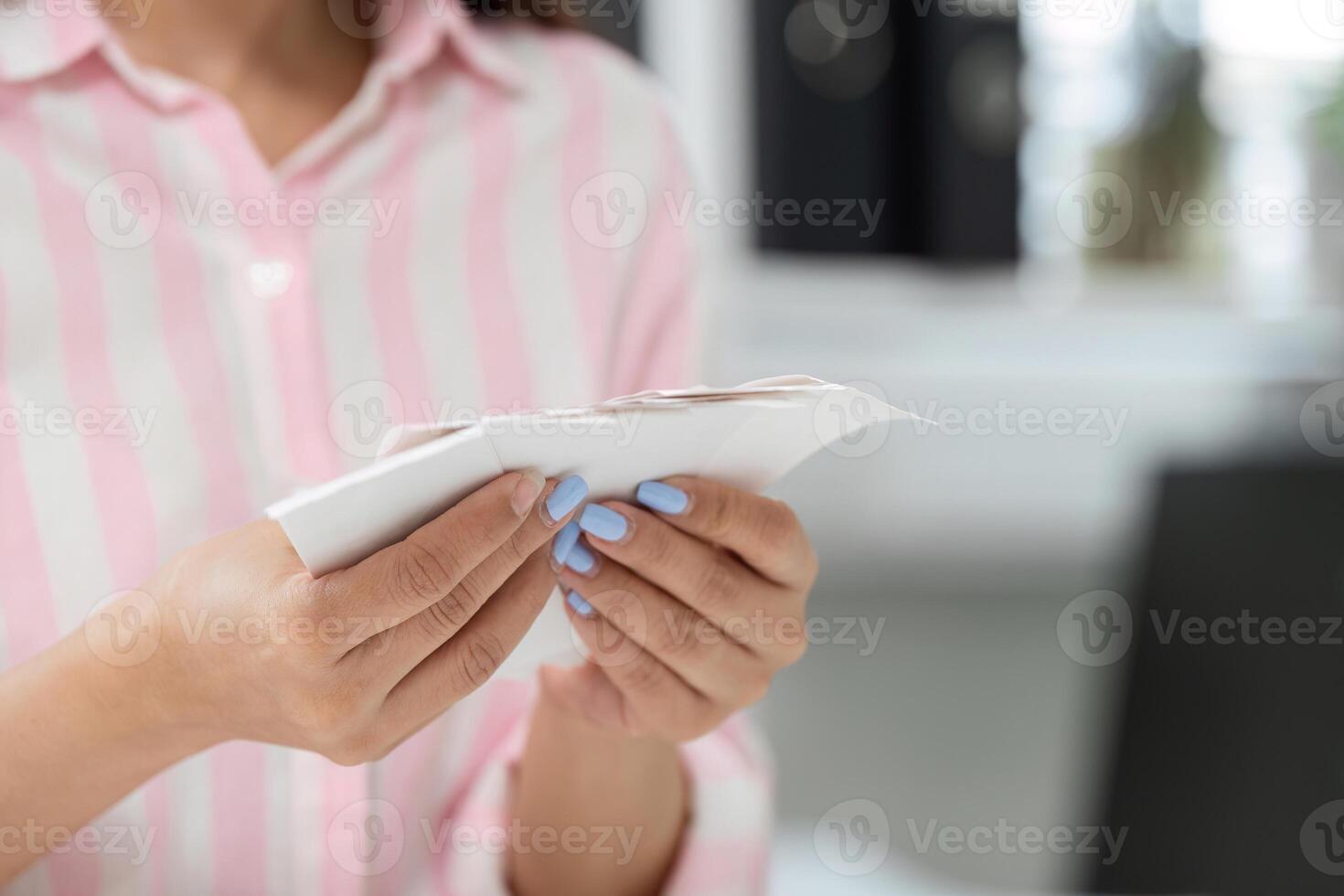 Managing Finances and Home Office Stress. A woman meticulously reviewing receipts in her organized workspace. photo