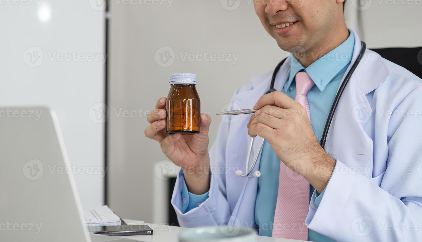 Medication Management and Patient Education. A healthcare provider explains medication using a bottle during a virtual consultation. photo