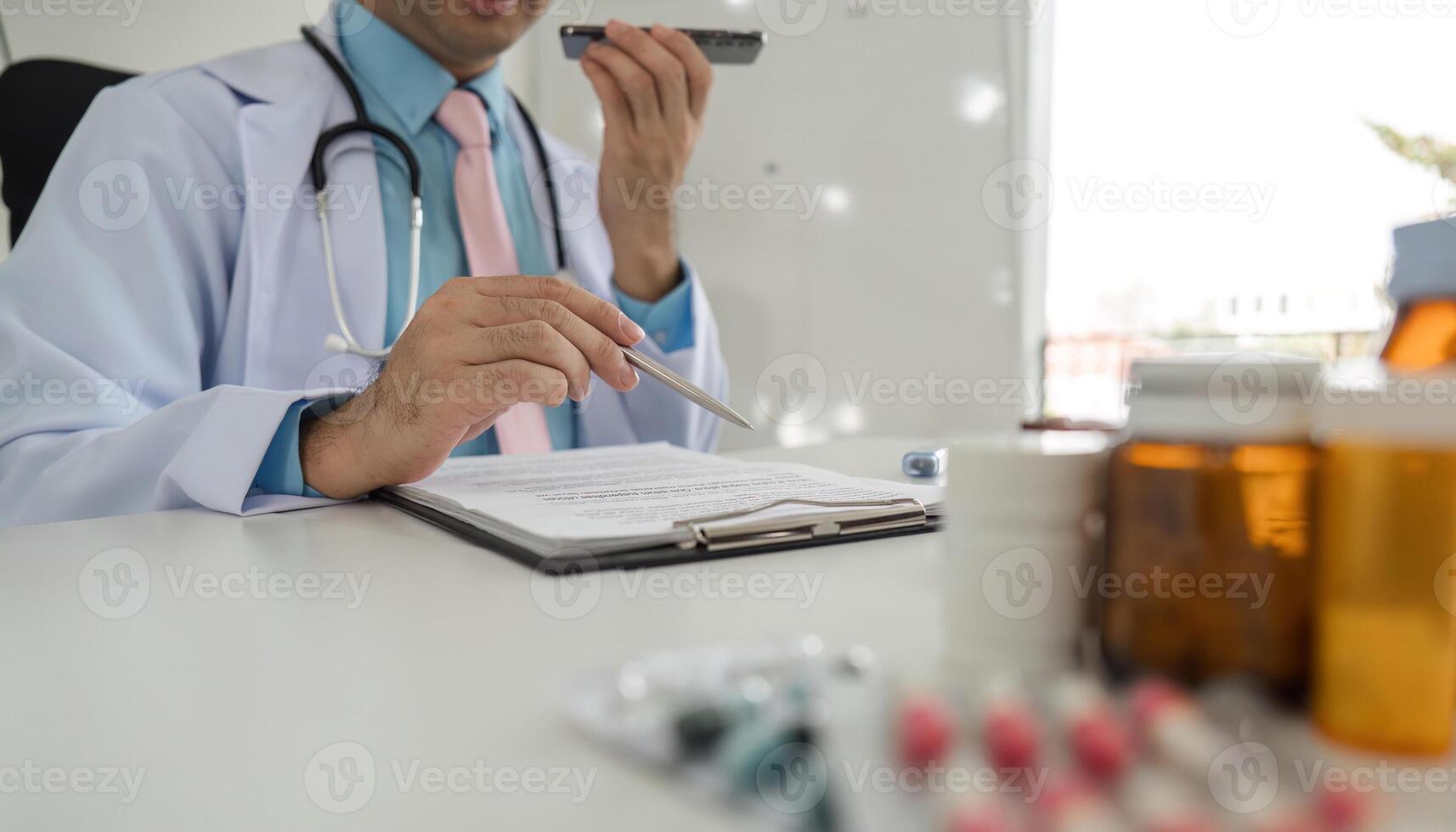 Healthcare Communication and Prescription Management. A doctor takes notes about medications during a remote patient inquiry. photo