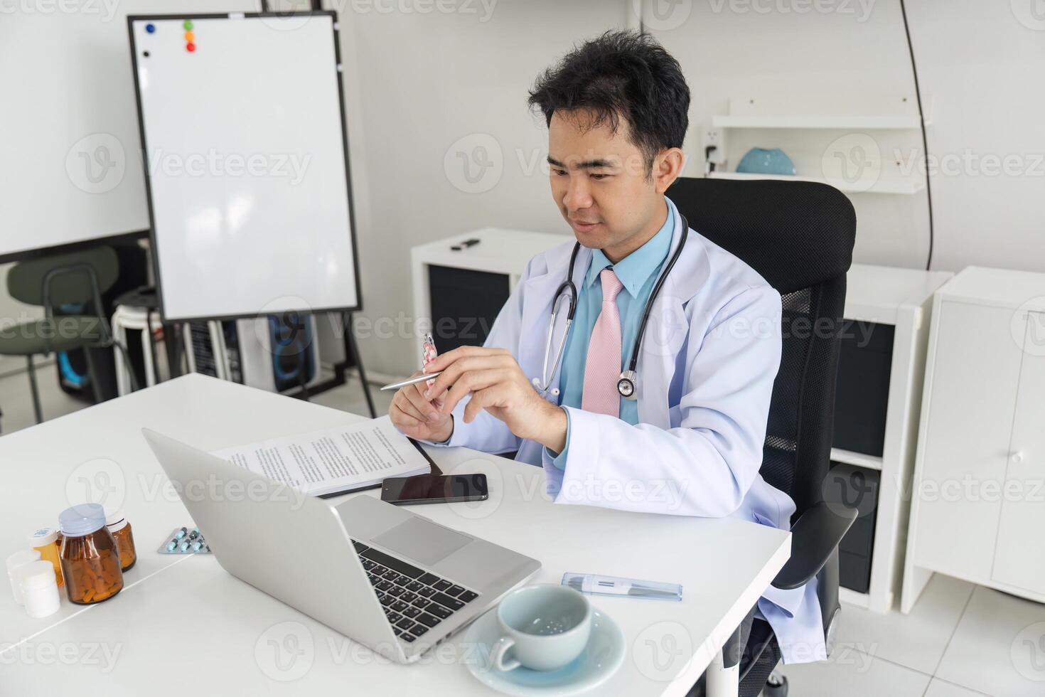 Doctor's Consultation and Professional Analysis. A physician reviews patient data while analyzing reports on a laptop. photo