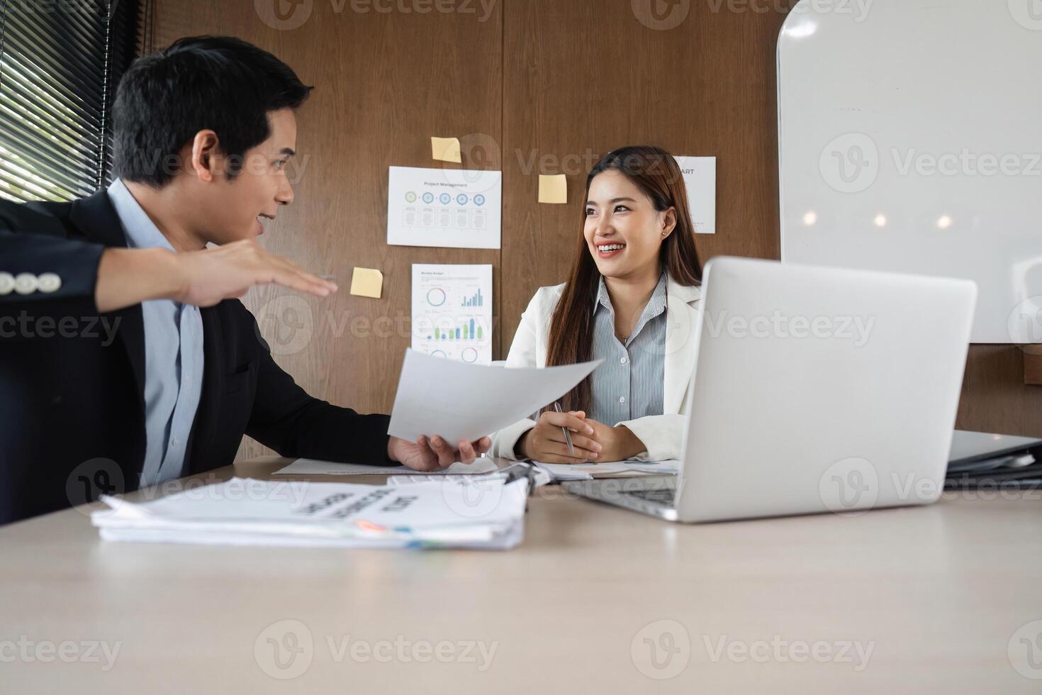 Engaging Discussion and Productive Conversations. Two colleagues share insights and strategies while discussing essential documents at work. photo