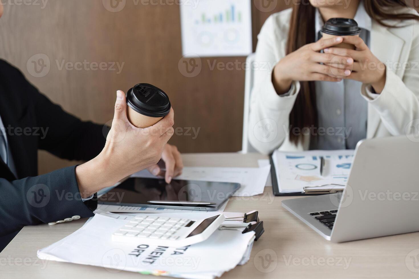 Workplace Interaction and Project Discussion. Professionals holding coffee cups while sharing project insights and enjoying a relaxed meeting. photo