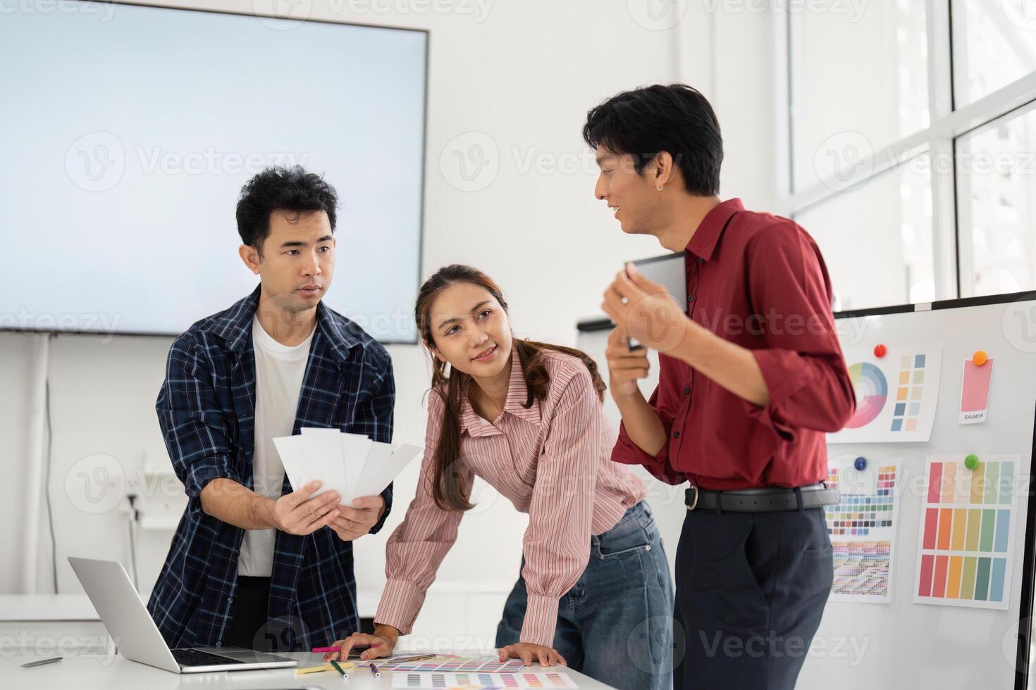 Design and Engagement. A creative team in a modern workspace reviewing design elements and making decisions together. photo