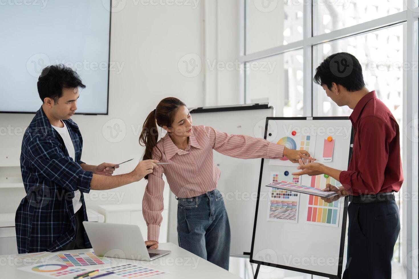 Team Collaboration and Creative Brainstorming. A vibrant team engages in a collaborative discussion over design concepts. photo