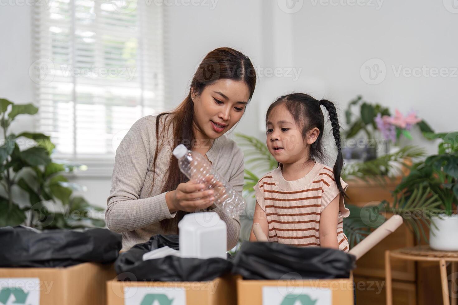 Engaging in Recycling and Family Bonding. A mother demonstrates the importance of recycling to her daughter through hands-on activities in their home. photo