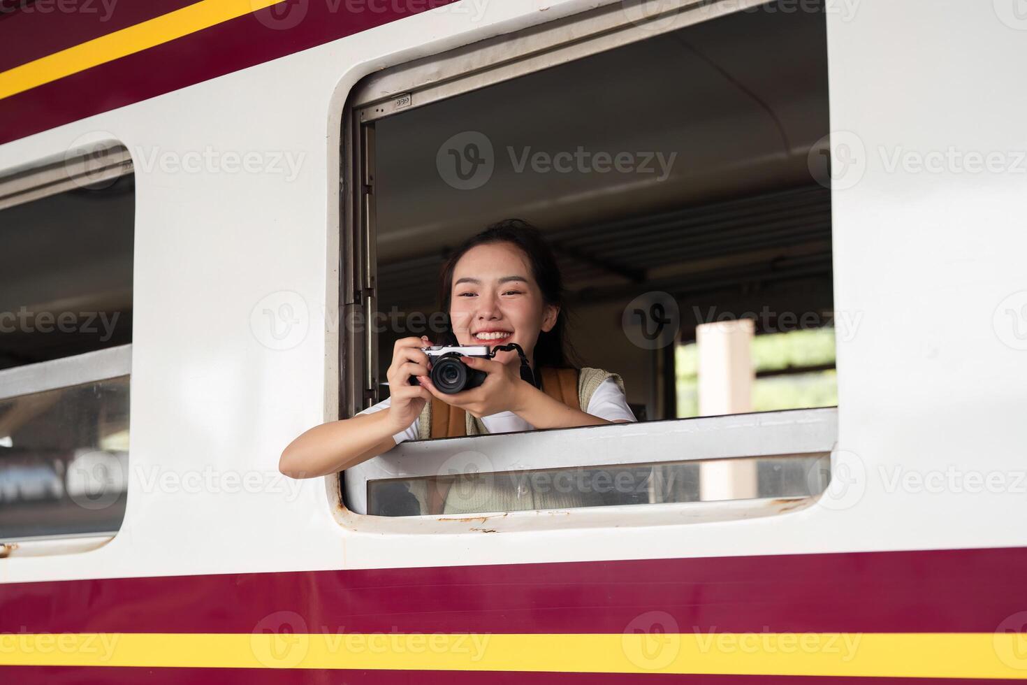 Photography and Travel Enthusiasm. A woman capturing a moment from her train window, filled with joy. photo